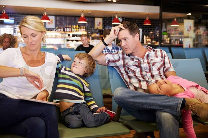 Family In Airport Departure Lounge Wait For Delayed Flight, stock photo