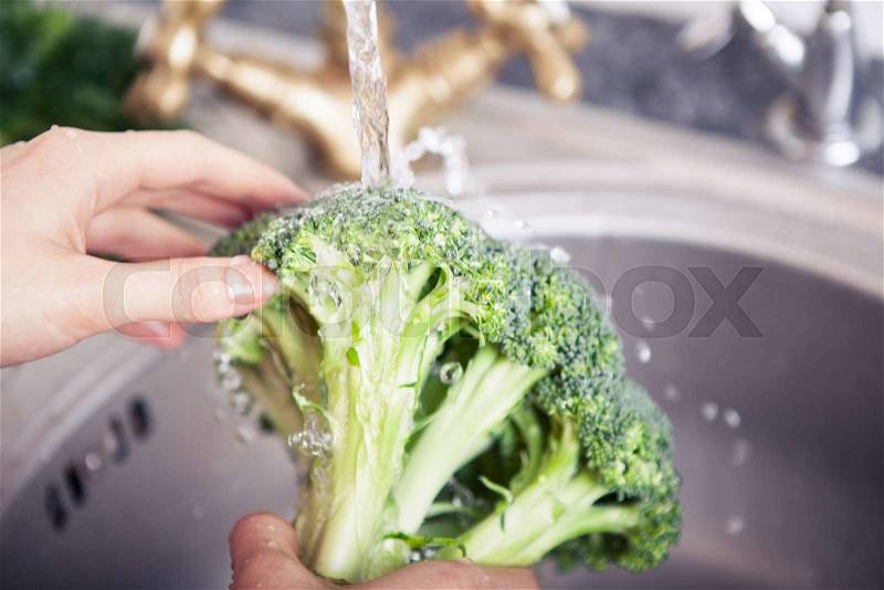 Woman\'s hands washing vegetables in sink in kitchen, stock photo