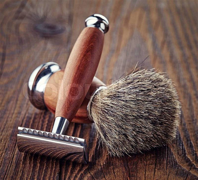 Wooden shaving razor and brush on wooden background, stock photo
