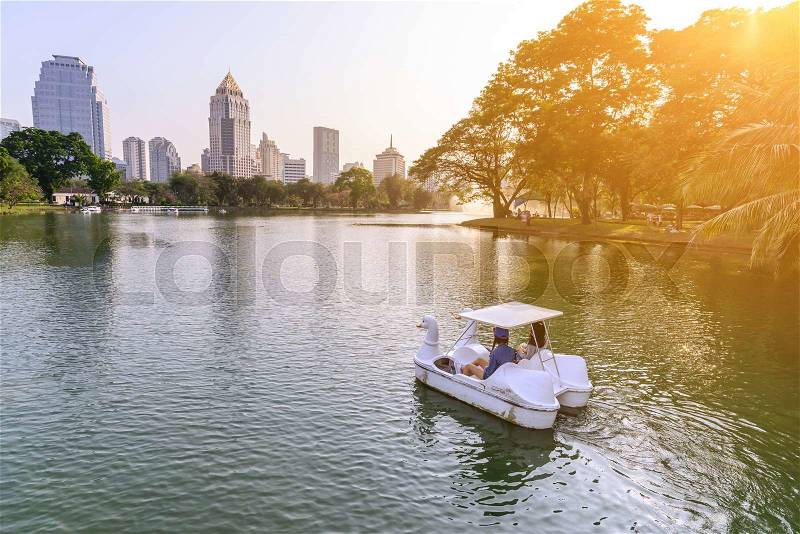 Womans playing pedal boats by urban lake in Bangkok. , stock photo