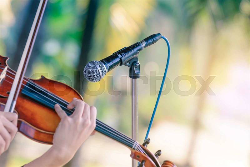 Black color microphone and violin playing in outdoor concert, stock photo