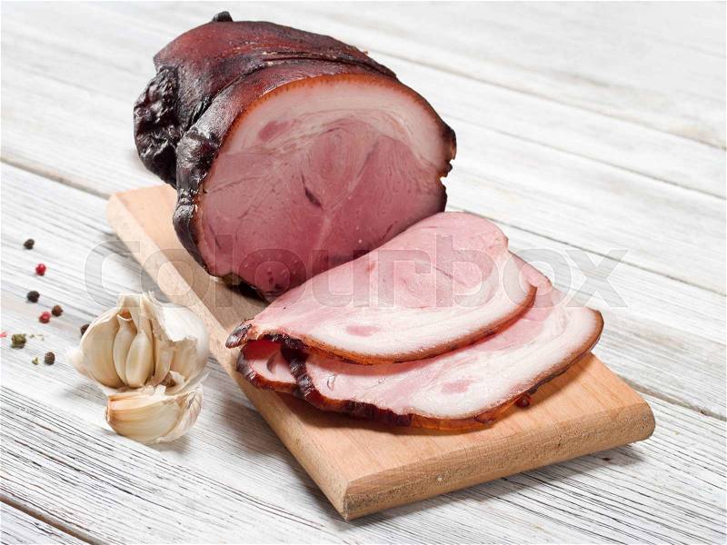 Smoked ham on wooden background, stock photo