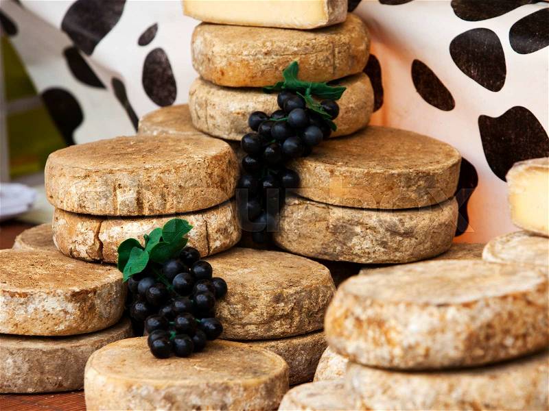 Stacked Tomme de Savoie cheese at market in France, stock photo