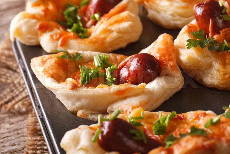 Freshly baked puff buns with sausage, cheese and onion macro in baking dish. horizontal , stock photo