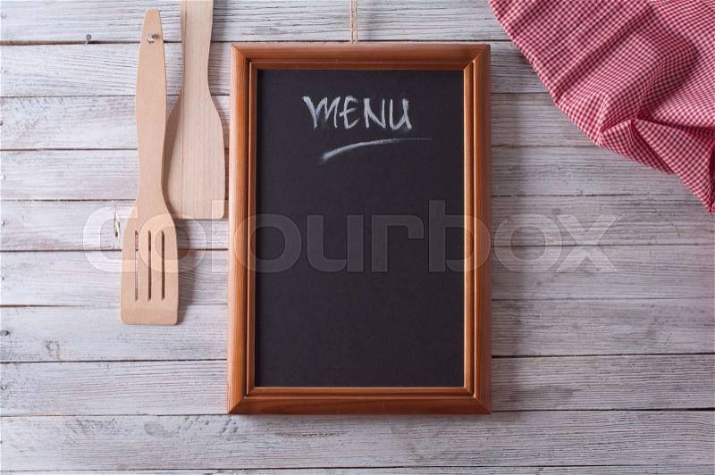 Blackboard on wooden surface and serving spoons, stock photo