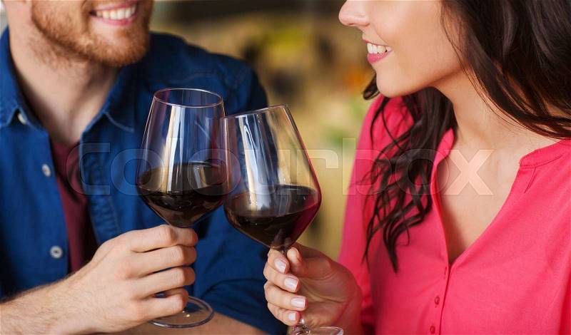 Leisure, celebration, food and drinks, people and holidays concept - smiling couple having dinner and drinking red wine at date in restaurant, stock photo