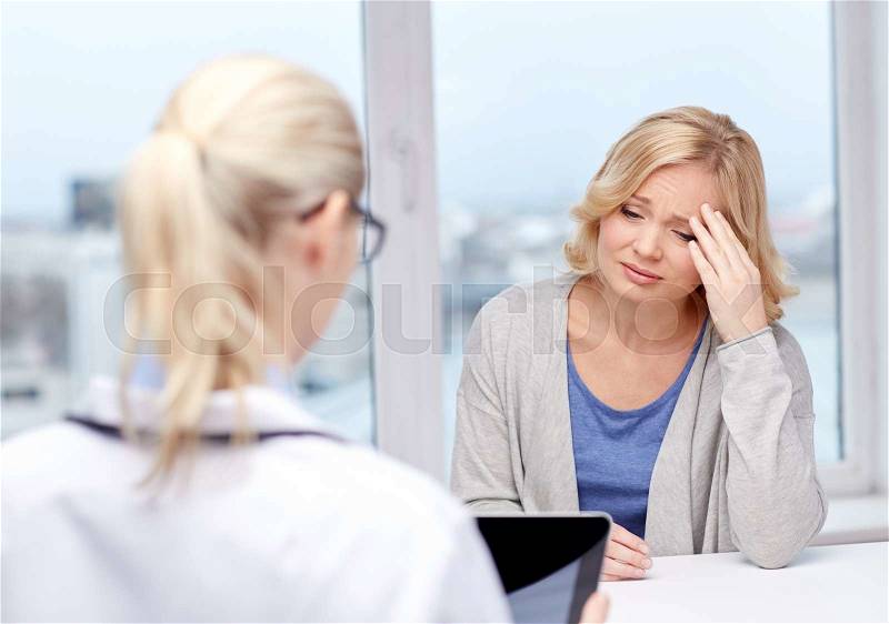 Medicine, health care and people concept - doctor with tablet pc computer and unhappy ill woman meeting at hospital, stock photo