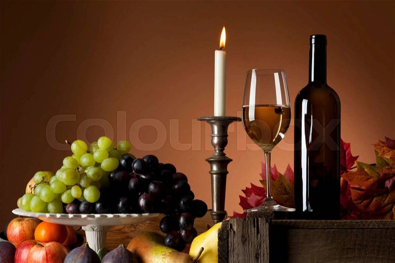 Still-life with white wine glass and bottle, grapes and other fruit, stock photo