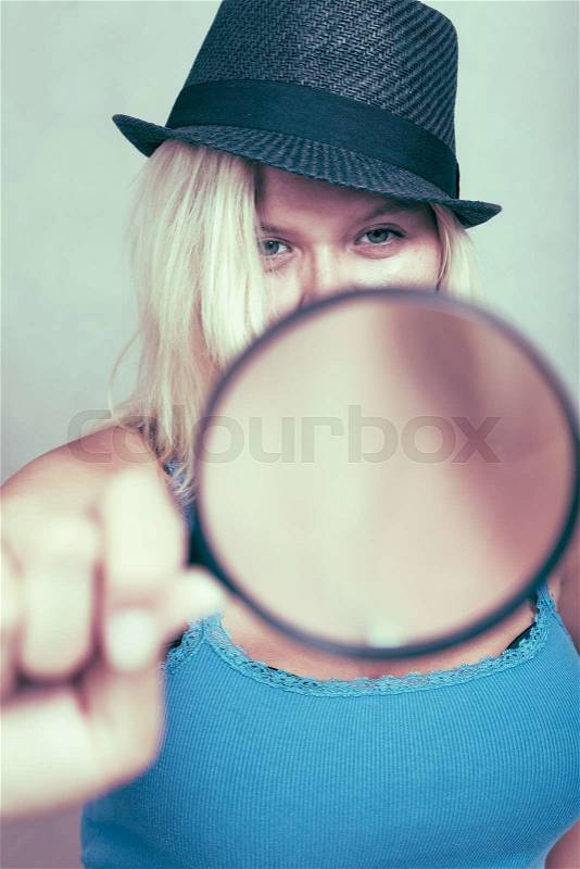 Female detective holding magnifying glass, research and investigation concept, stock photo