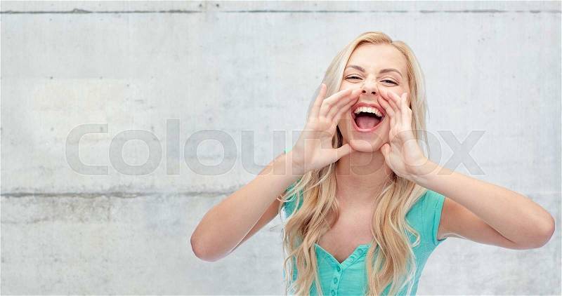 Emotions, expressions and people concept - young woman or teenage girl shouting over gray concrete wall background, stock photo