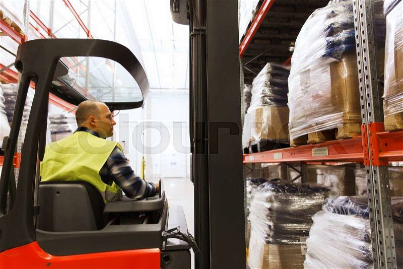 Wholesale, logistic, loading, shipment and people concept - man or loader operating forklift loader at warehouse, stock photo