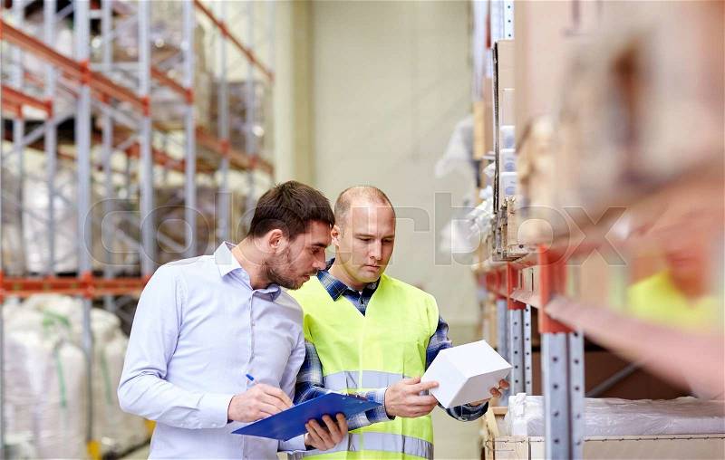 Wholesale, logistic, people and export concept - manual worker and businessmen with clipboard and box at warehouse, stock photo