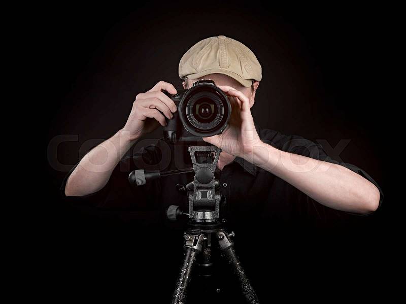 A photographer with a nice camera on black background, stock photo
