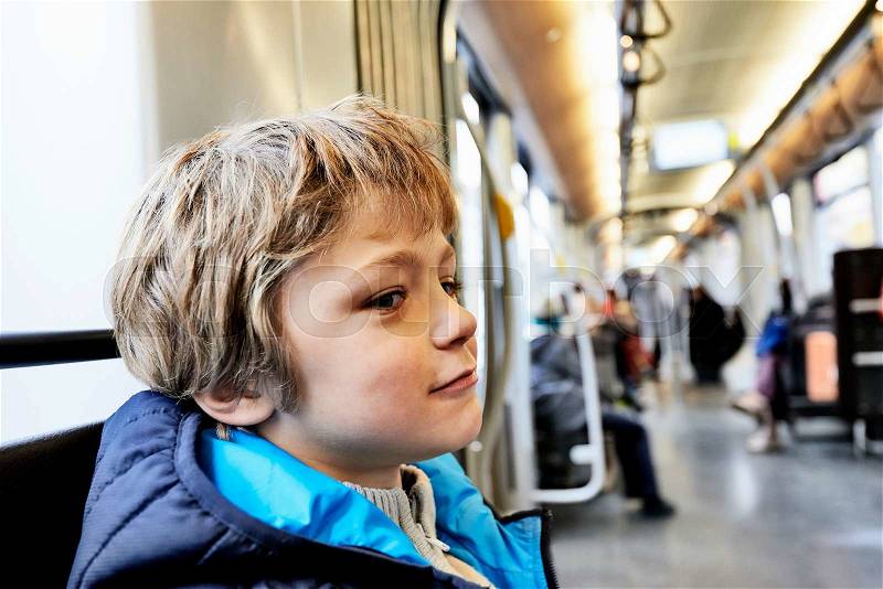 Cute young boy in a public transport, stock photo