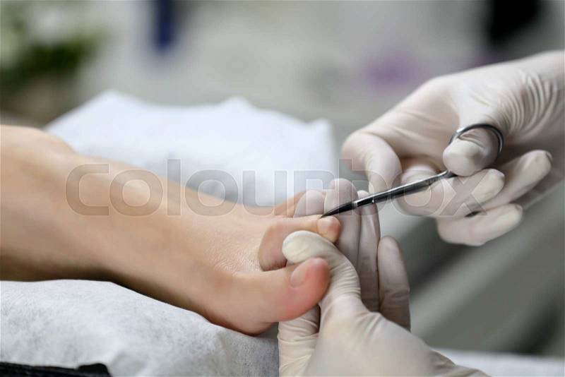 Close up Cutting cuticle on foot, nail scissors. Pedicure process, stock photo