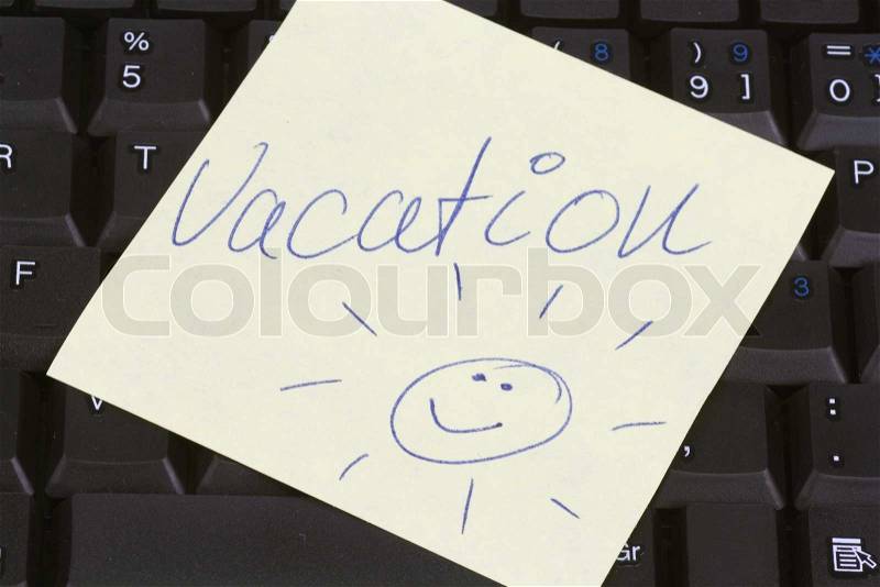 Yellow post it paper on a keyboard with message vacation, stock photo