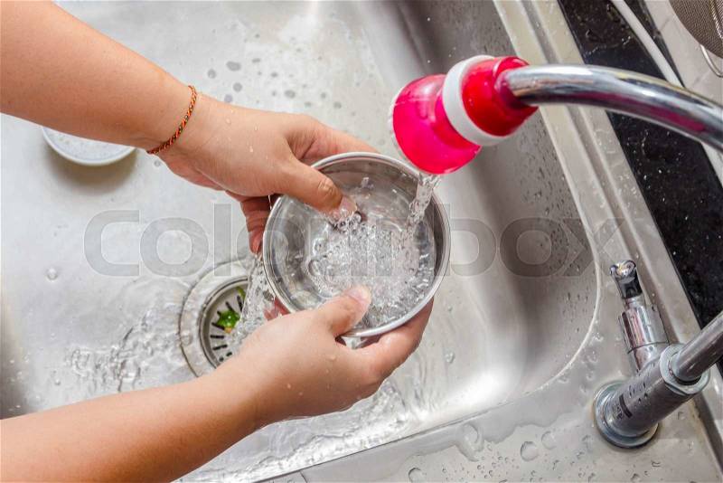 Women washing the pot in sink, stock photo