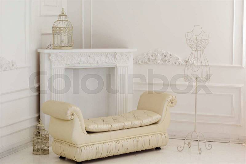 Light interior of room with white sofa and vintage metal hanger with wire dress form , stock photo