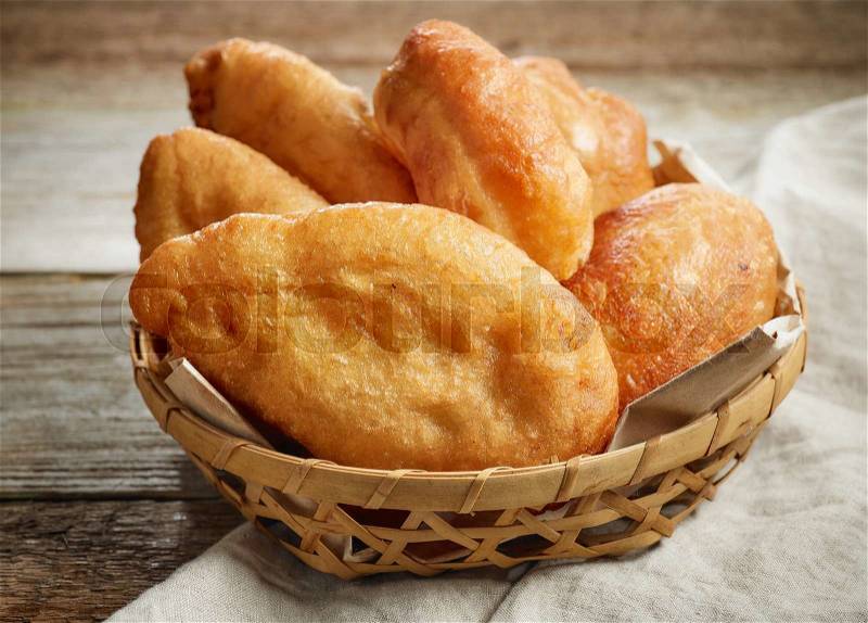 Fried meat pies on wooden table, stock photo