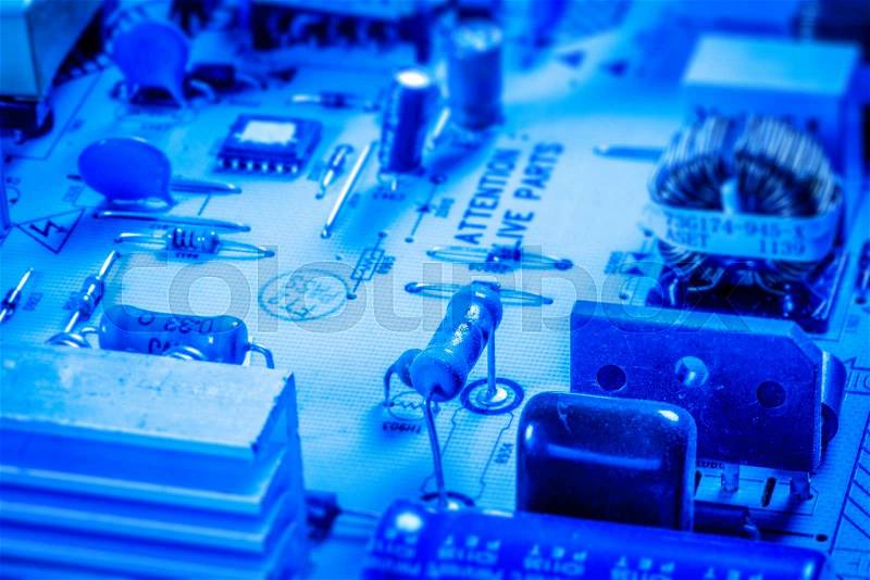 Electronics board with capacitors and chips in blue color, stock photo