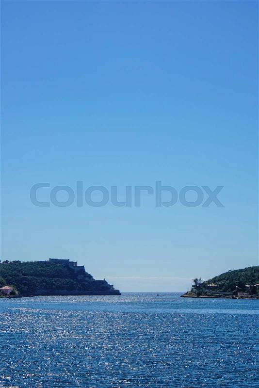 Overlooking the crystal clear sea against sea exit between two mountains, stock photo