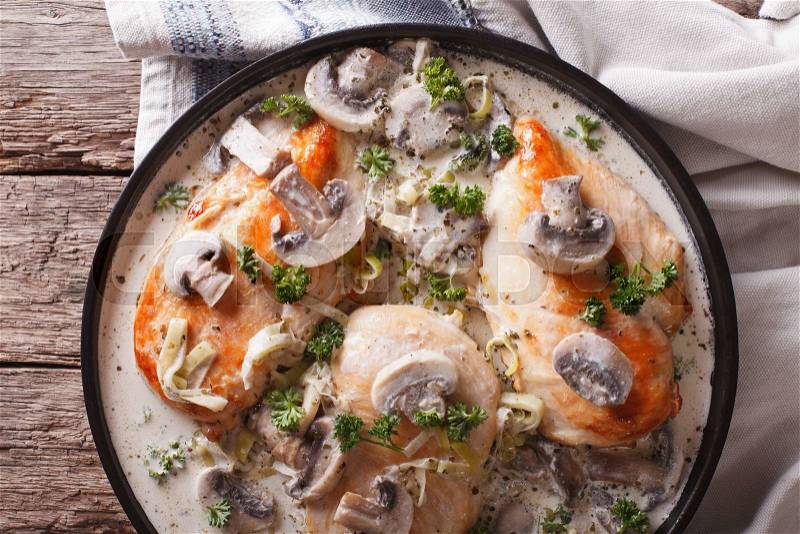 Chicken with mushroom sauce close-up on a plate on the table. horizontal view from above , stock photo