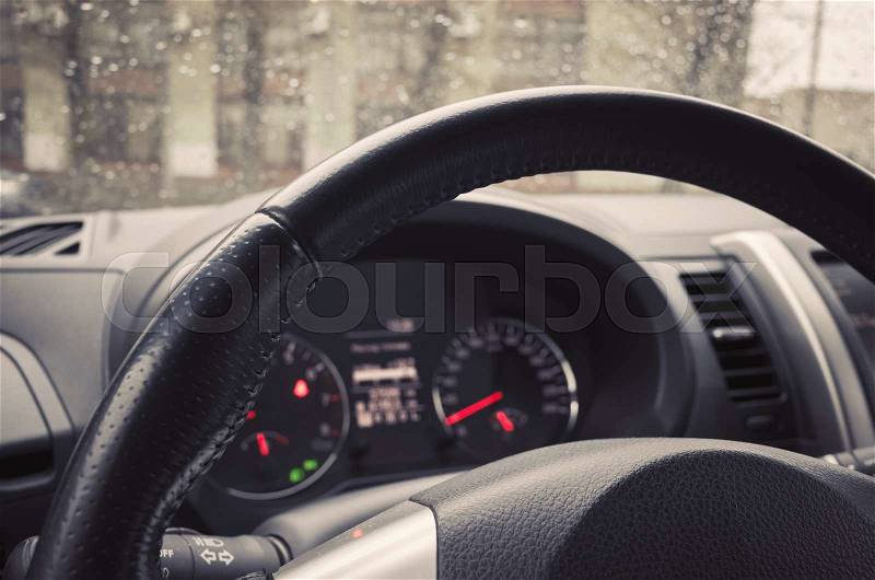 Modern car interior fragment with steering wheel and control panel. Tonal correction photo filter effect, old style, stock photo