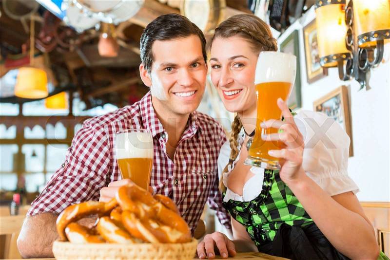 Couple drinking wheat beer in bavarian restaurant, stock photo