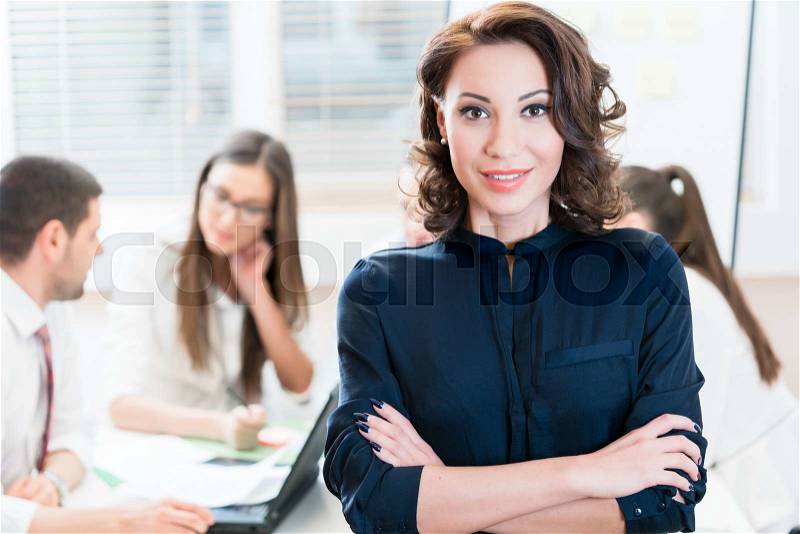 Manager with her team working in the office, stock photo