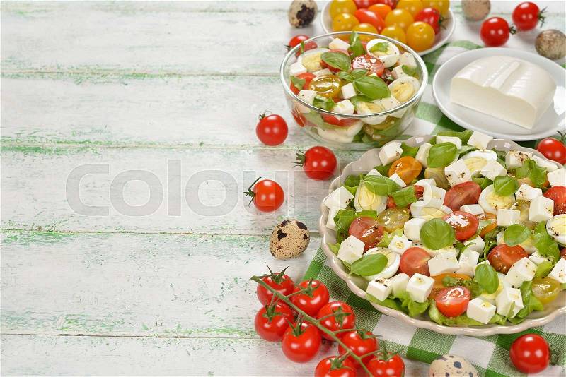 Salad with cherry tomatoes, eggs and cheese on white background, stock photo