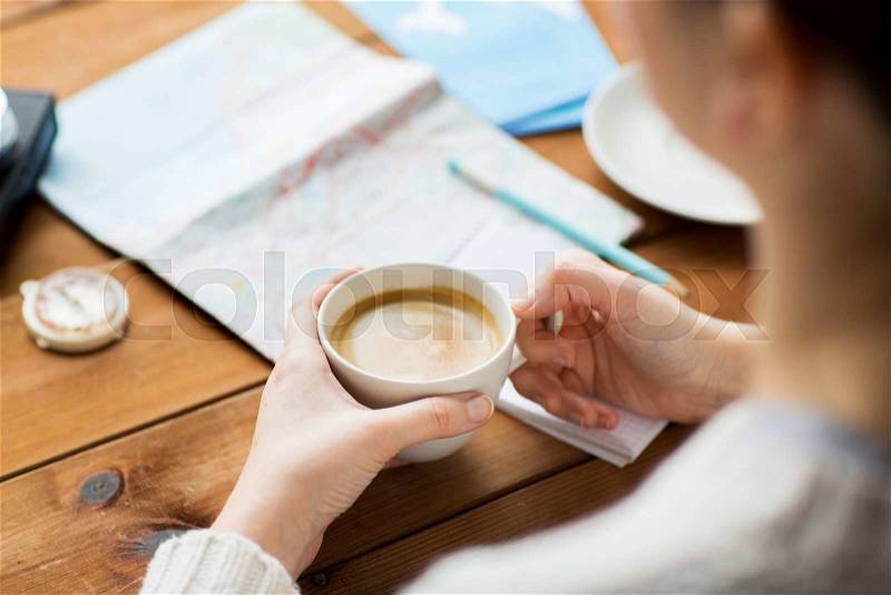Vacation, tourism, travel, destination and people concept - close up of hands with coffee cup and travel stuff, stock photo