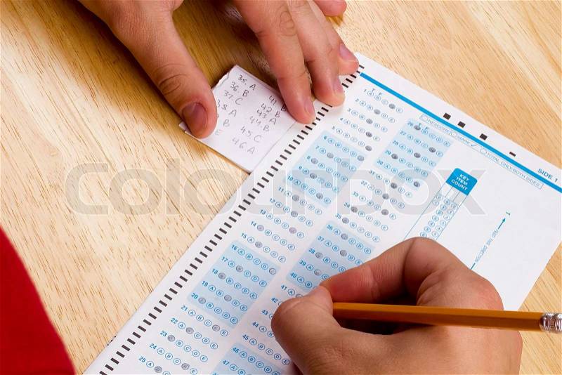 Student using a cheat sheet to cheat on his test, stock photo