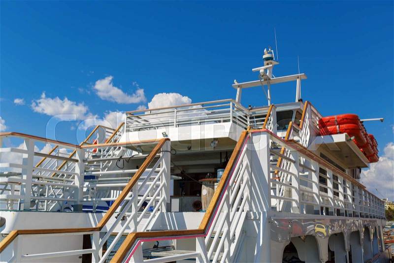 Close-up fragment of the deck with stairs white cruise ship on a background of blue sky with clouds, stock photo