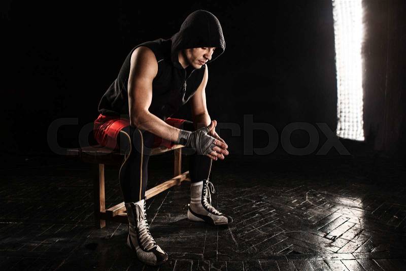 The muscular boxer sitting and resting on black, stock photo