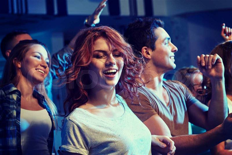 Party, holidays, nightlife and people concept - happy friends dancing at night club, stock photo