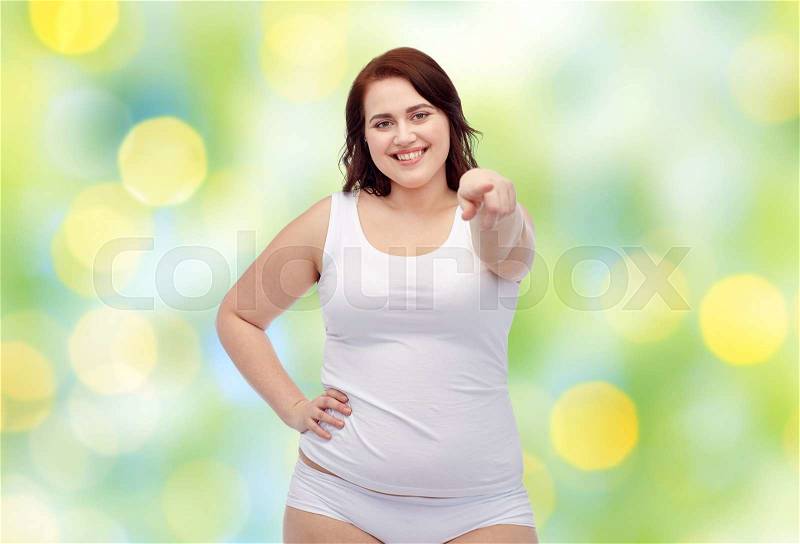 Gesture, weight loss and people concept - smiling young plus size woman in underwear showing over green lights background, stock photo