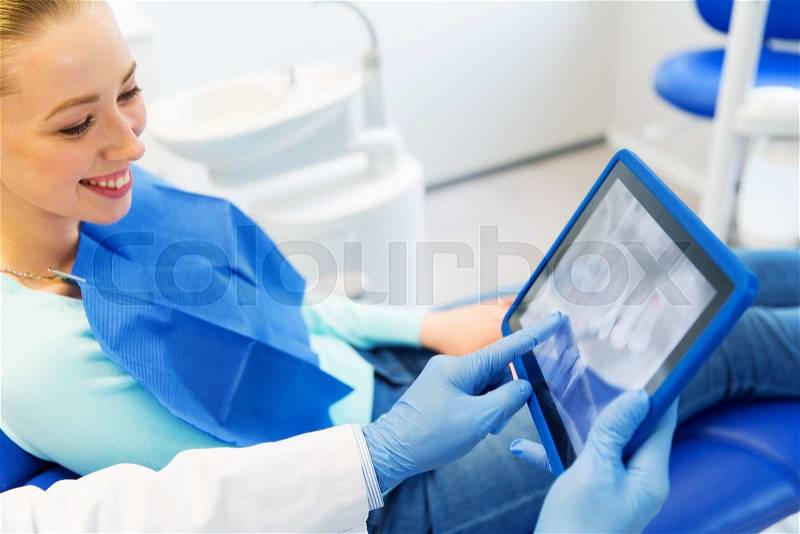 People, medicine, stomatology and health care concept - close up of dentist hands showing teeht x-ray on tablet pc computer to woman patient at dental clinic office, stock photo