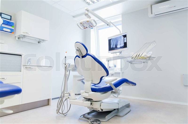 Dentistry, medicine, medical equipment and stomatology concept - interior of new modern dental clinic office with chair, stock photo