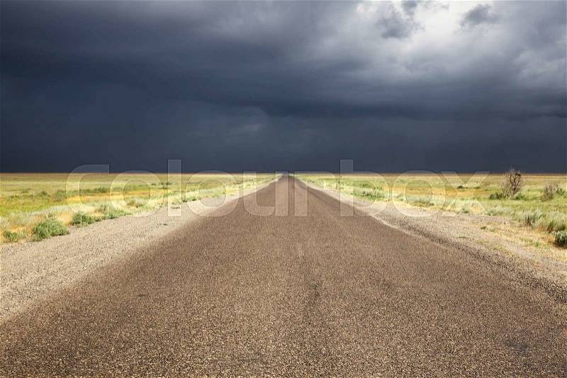 Old road in desert and storm sky in Almaty region, Kazakhstan, Central Asia, stock photo