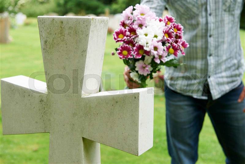 Man Laying Flowers On Grave, stock photo