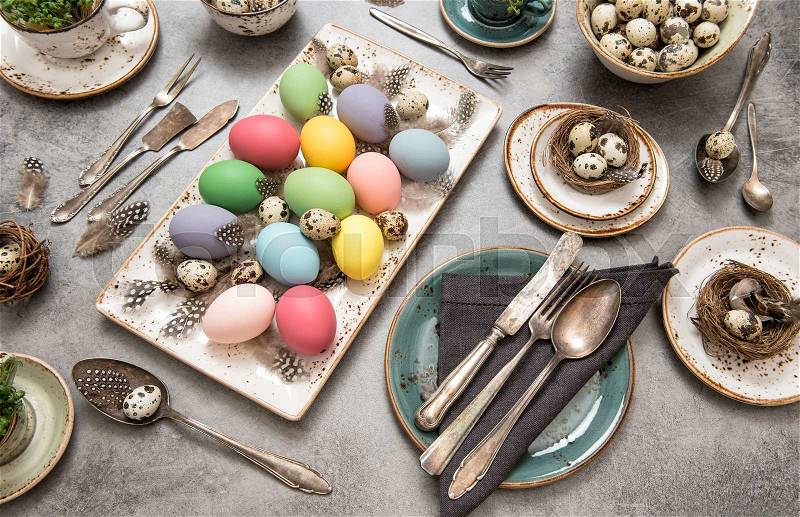 Festive table place setting decoration with colored eggs. Easter still life. Top view, stock photo