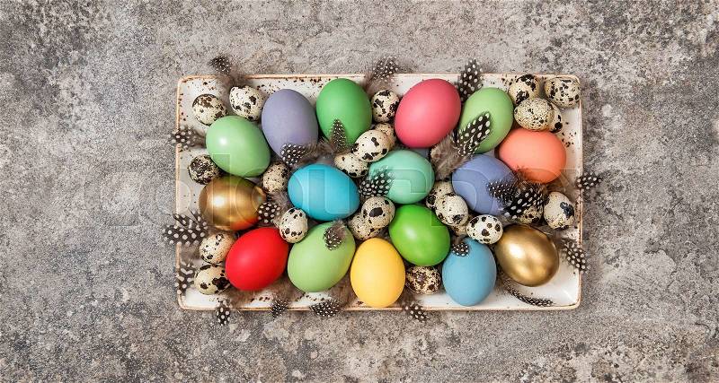 Easter eggs decoration on grey stone background. Colorful holidays banner, stock photo
