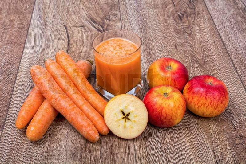 Blended light orange smoothie with ingredients on wooden table, stock photo