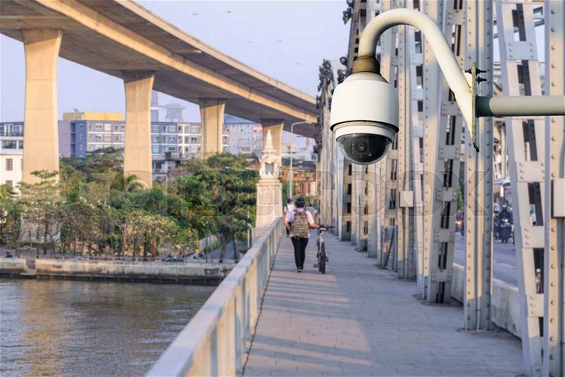 Security camera monitoring events at walk path on bridge in city, stock photo
