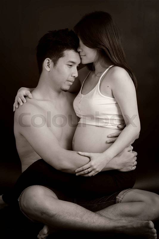 Beautiful young asian couple expecting baby and hug together, stock photo