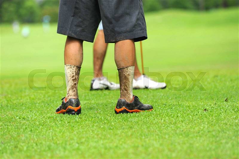 Dirty legs of golf player in raining game, stock photo