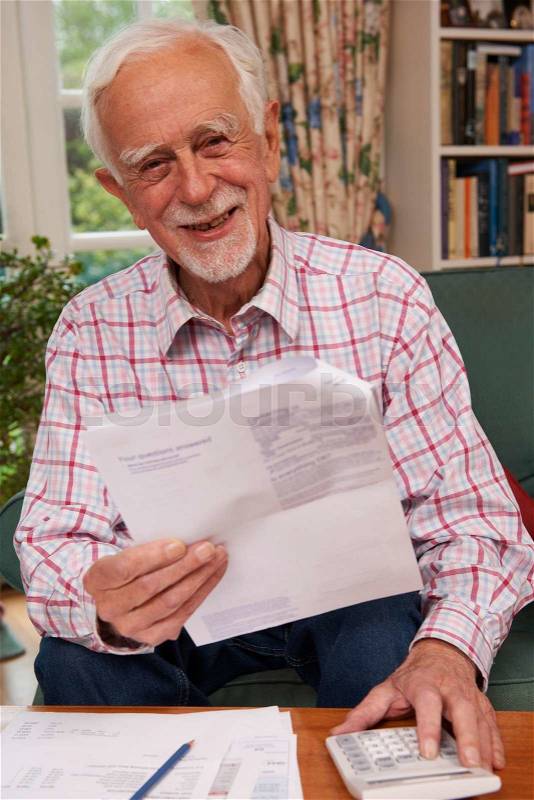 Senior Man Going Through Finances Looking Happy And Secure, stock photo