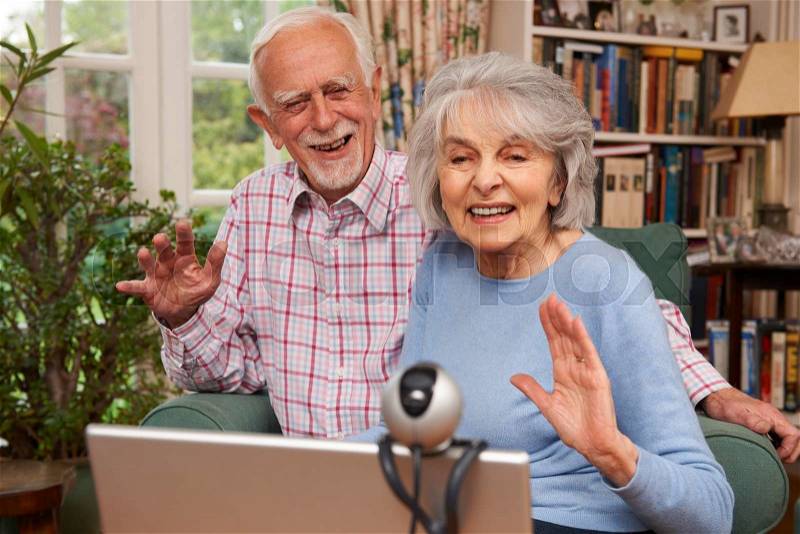 Senior Couple Using Laptop And Webcam To Talk To Family, stock photo