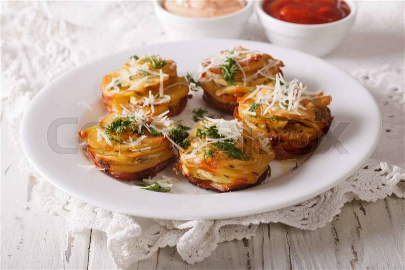 Tasty food: Sliced baked potatoes with Parmesan cheese and dill close-up on the table. horizontal , stock photo