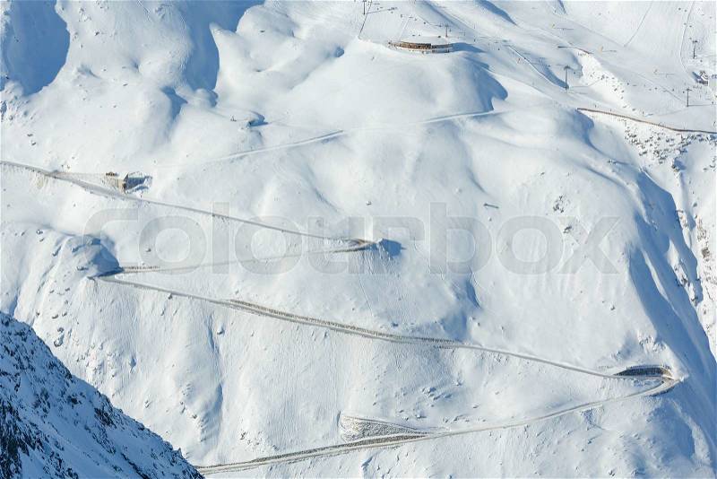 Scenery from the cabin ski lift at serpentine road on snowy slope (Tyrol, Austria). All people are unrecognizable. , stock photo